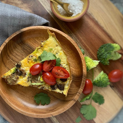 image of quiche with vegetables on a cutting board with broccoli and tomato